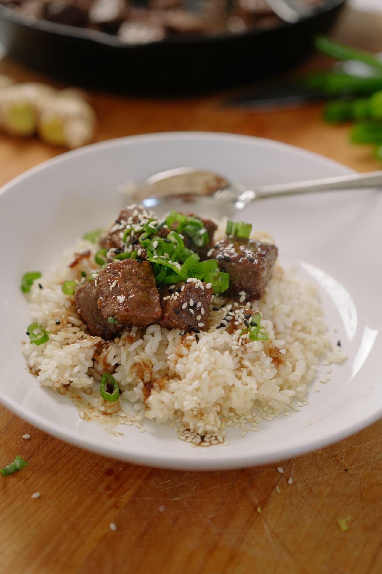 Sesame beef bites over steamed rice with scallions