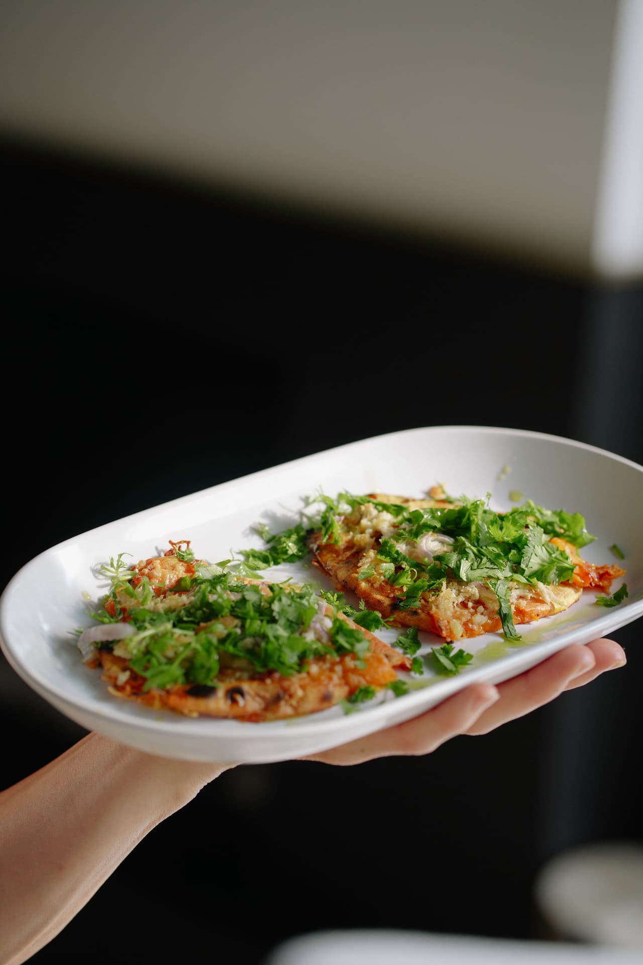 Grilled flatbread topped with herbs and shaved onion