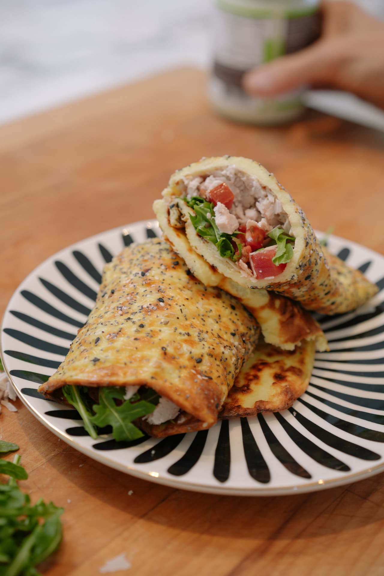 Everything-seasoned egg wraps with chicken, arugula and tomato